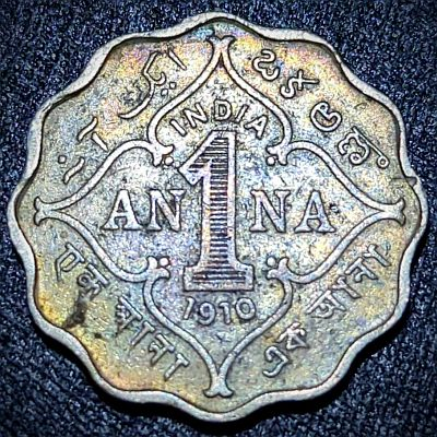 Name of country, denomination, date below within floral pattern. One anna in four languages, Urdu, Telugu, Bengali and Devanagari outside. Lettering: ایک آن ఒకఅణా INDIA AN 1 NA 1910 एक आना এক আনা Translation: One Anna <br>One Anna One Anna One Anna