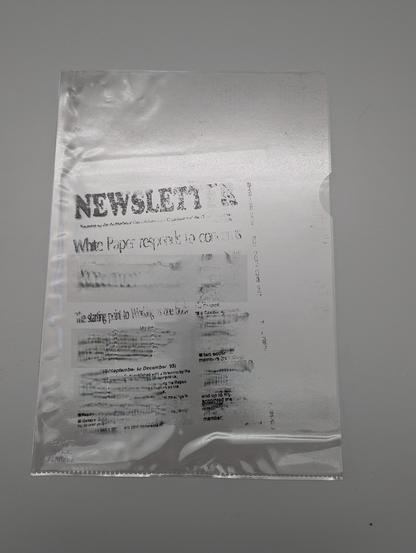 Transparent Pplastic document sleeve with transfer of black printer ink.
*Purposeful blurring to obscure text due to 30 year rule.