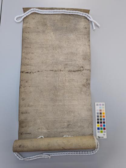 Rolled parchment with nearly illegible writing across the surface.